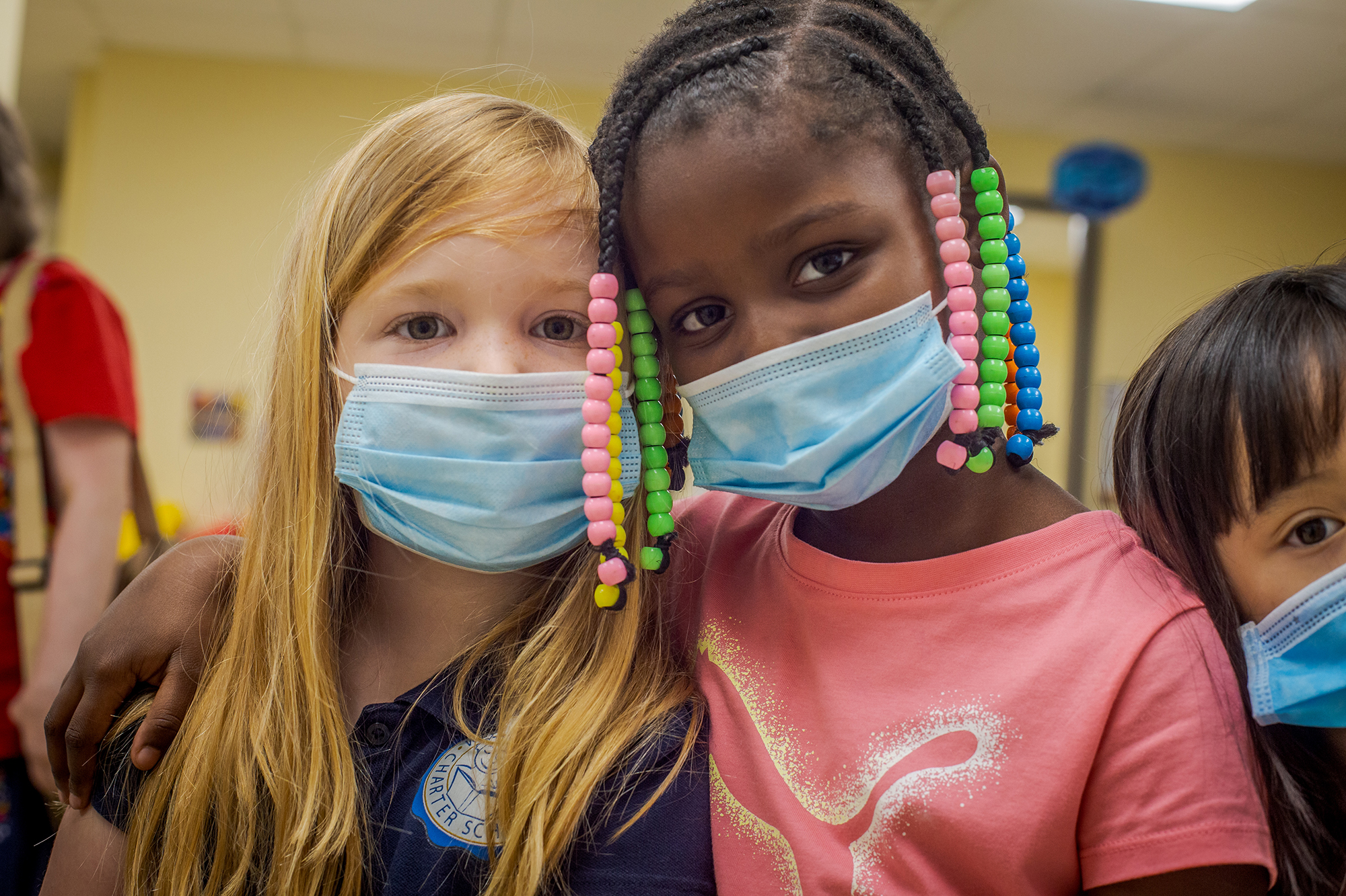 two little girls together wearing masks