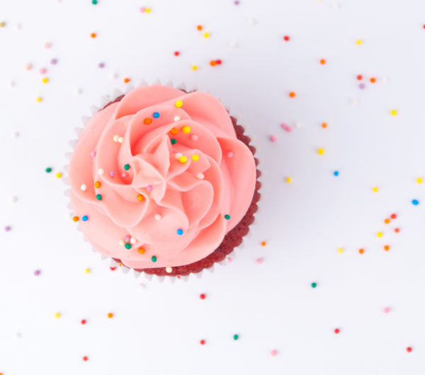 cupcake topped with pink icing and sprinkles