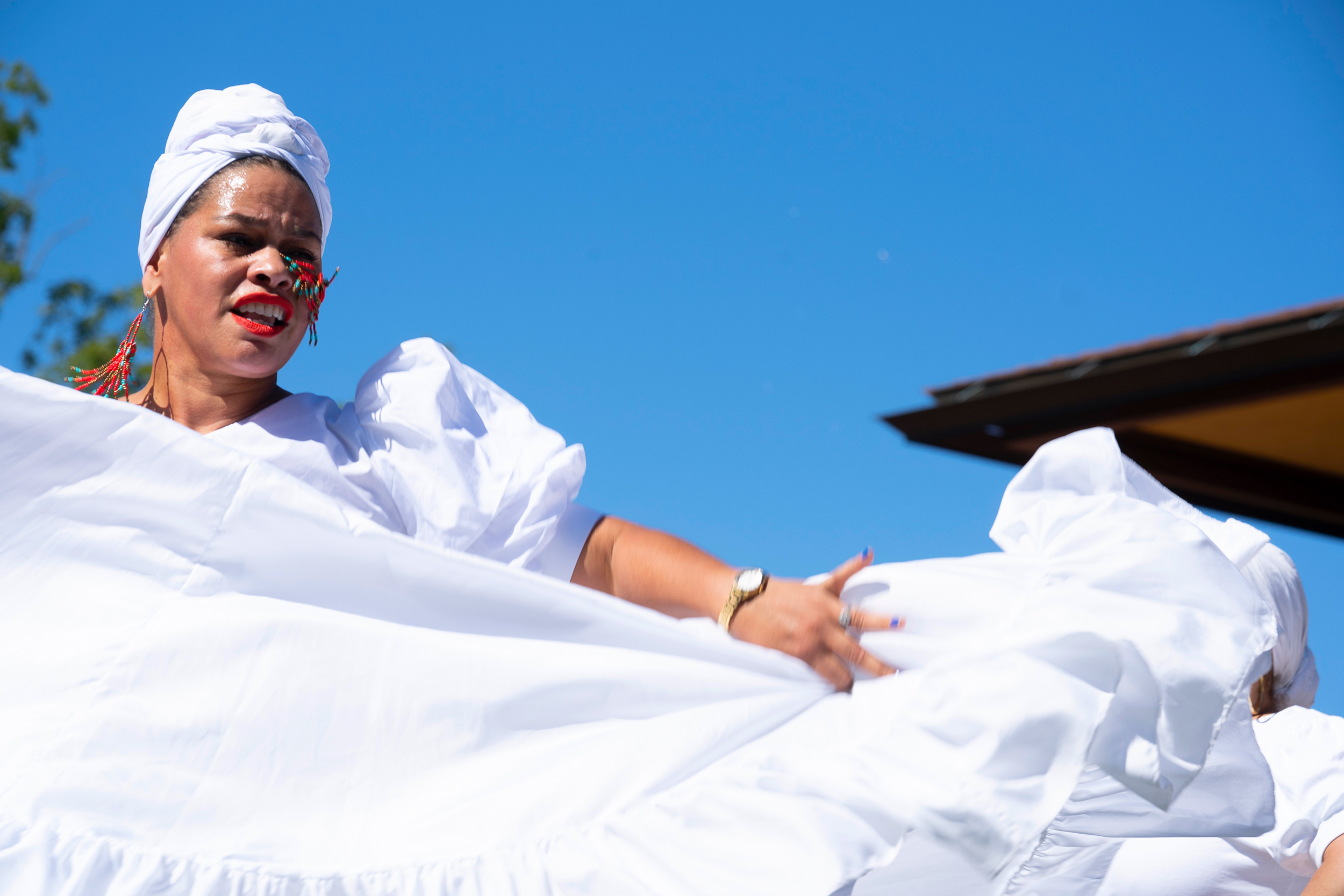 hispanic woman in a long white dress dancing