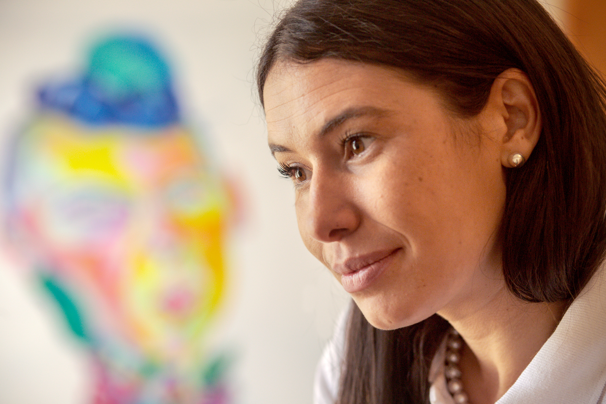 portrait of talia rodriguez actively looking with a piece of abstract artwork behind her