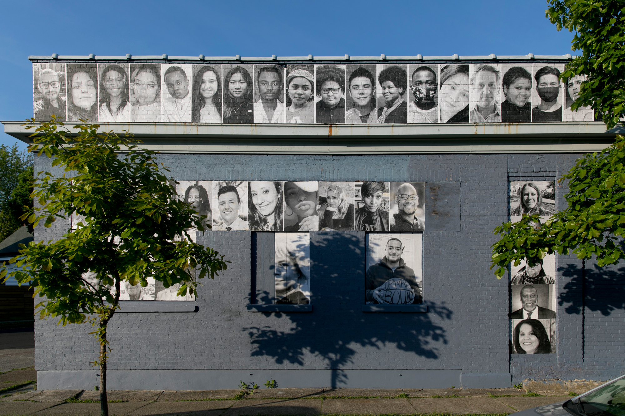 people's portraits on the side of a brick building
