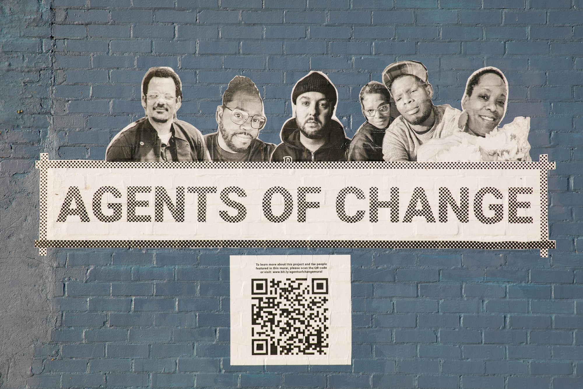 agents of change sticker on the side of a brick building with QR code