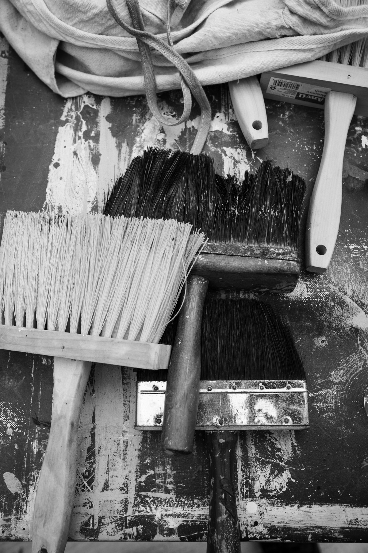black and white photo of paintbrushes on a wooden surface