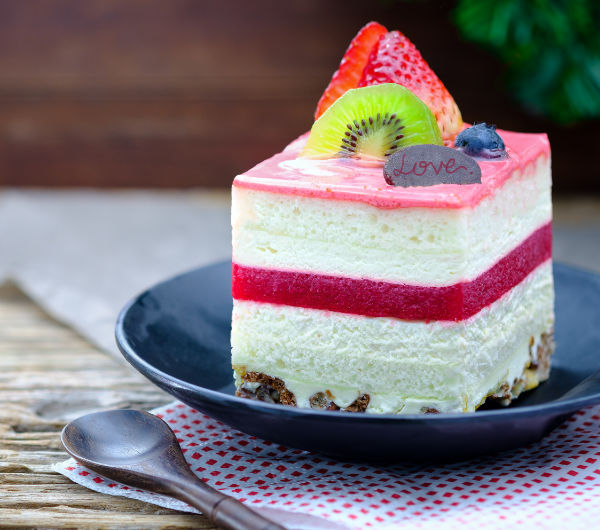 slice of cake topped with whipped topping and fruit